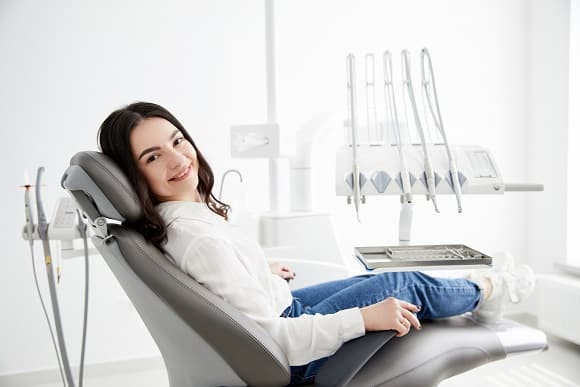 woman sitting in dental chair and getting sedation dentistry