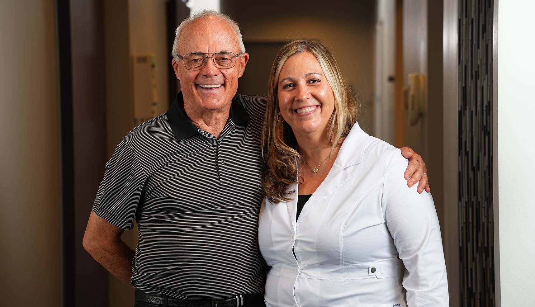 Duane smiling with Dr. Hedrick after completing his dental implant treatment at Longmont Dental Loft.